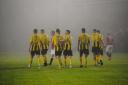 In foggy conditions Falmouth Town celebrate taking the lead against Penryn.