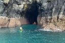 A Lizard Lifeboat crew member tries to access the second kayaker in the cave