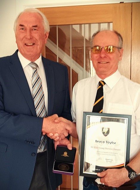 Bruce Taylor (left) is presented with his gold medal by Cornwall County FA director Steve Carpenter. Image: Margaret Taylor