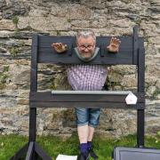 Rev Danny Reed in the stocks ready to have wet sponges thrown at him