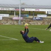 Goalkeeper Ethan Fearn warms up before the match