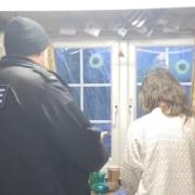 A police officer speaks to April in the kitchen of her home in a still from the video