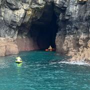 A Lizard Lifeboat crew member tries to access the second kayaker in the cave