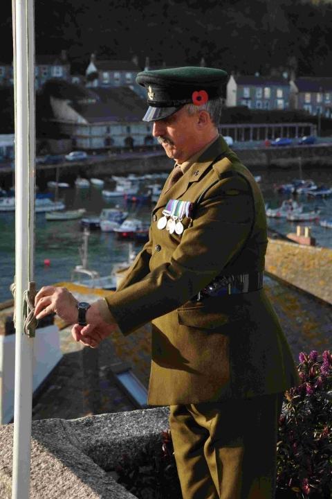 Lance Corporal Dave Dunne lowers the flag