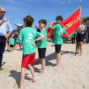 William speaks with members of Holywell Bay Surf Life Saving Club during a visit to Fistral Beach in Newquay