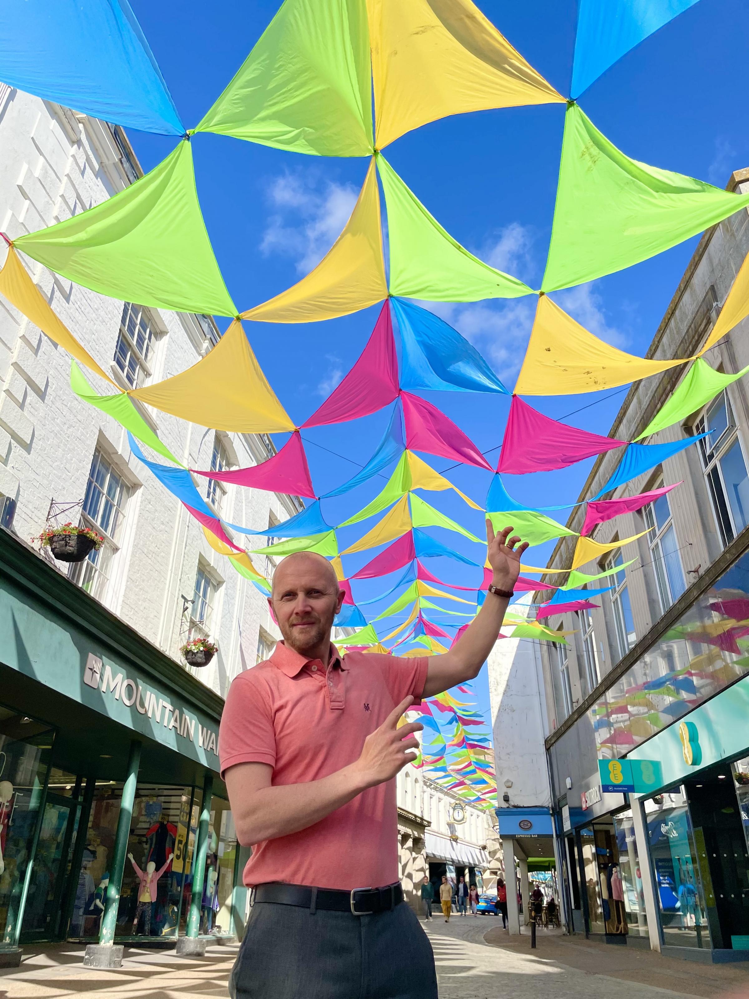 Richard Wilcox, Falmouth BID manager underneath a canopy of flags
