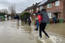 People wade through flood water in Loughborough (Callum Parke/PA).