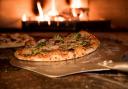 Pizza cooking in a pizza oven. Picture: Canva