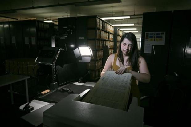 Falmouth Packet: Photo via PA shows Findmypast technician Laura Gowing scans individual pages of the 30,000 volumes of the 1921 Census at the Office for National Statistics (ONS) near Southampton.