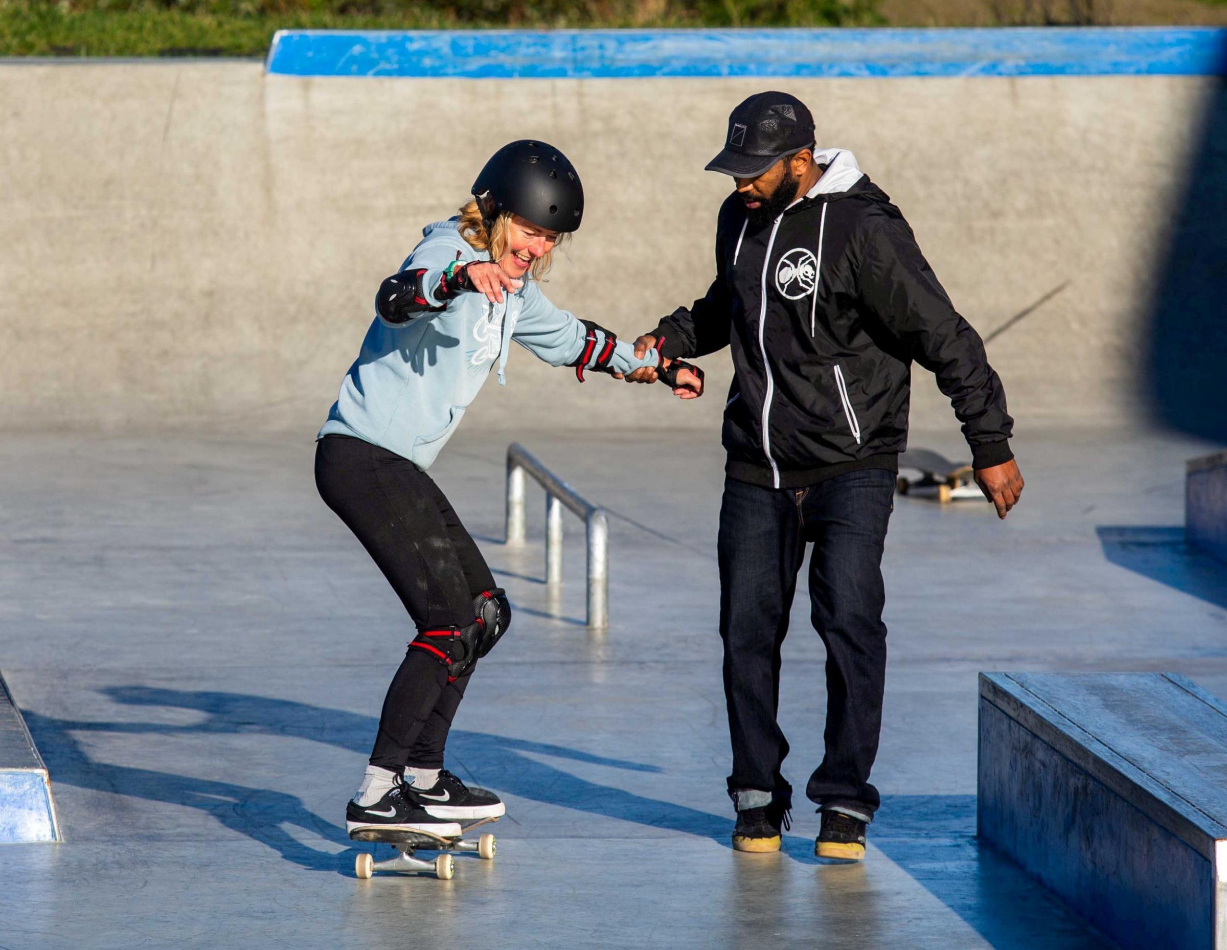 Coach Zain Ishmael helps Lisa Woodruff at the Mount Hawke Skate Park Picture: SWNS