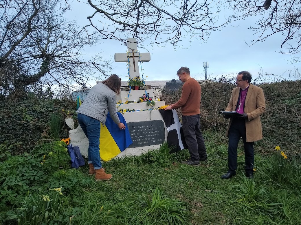 The Ukranian and Cornish flags are laid on the cross