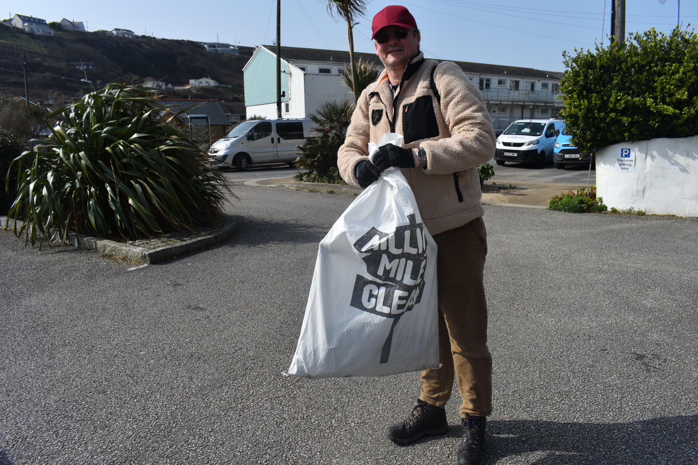 A volunteer picks litter at Portreath Beach