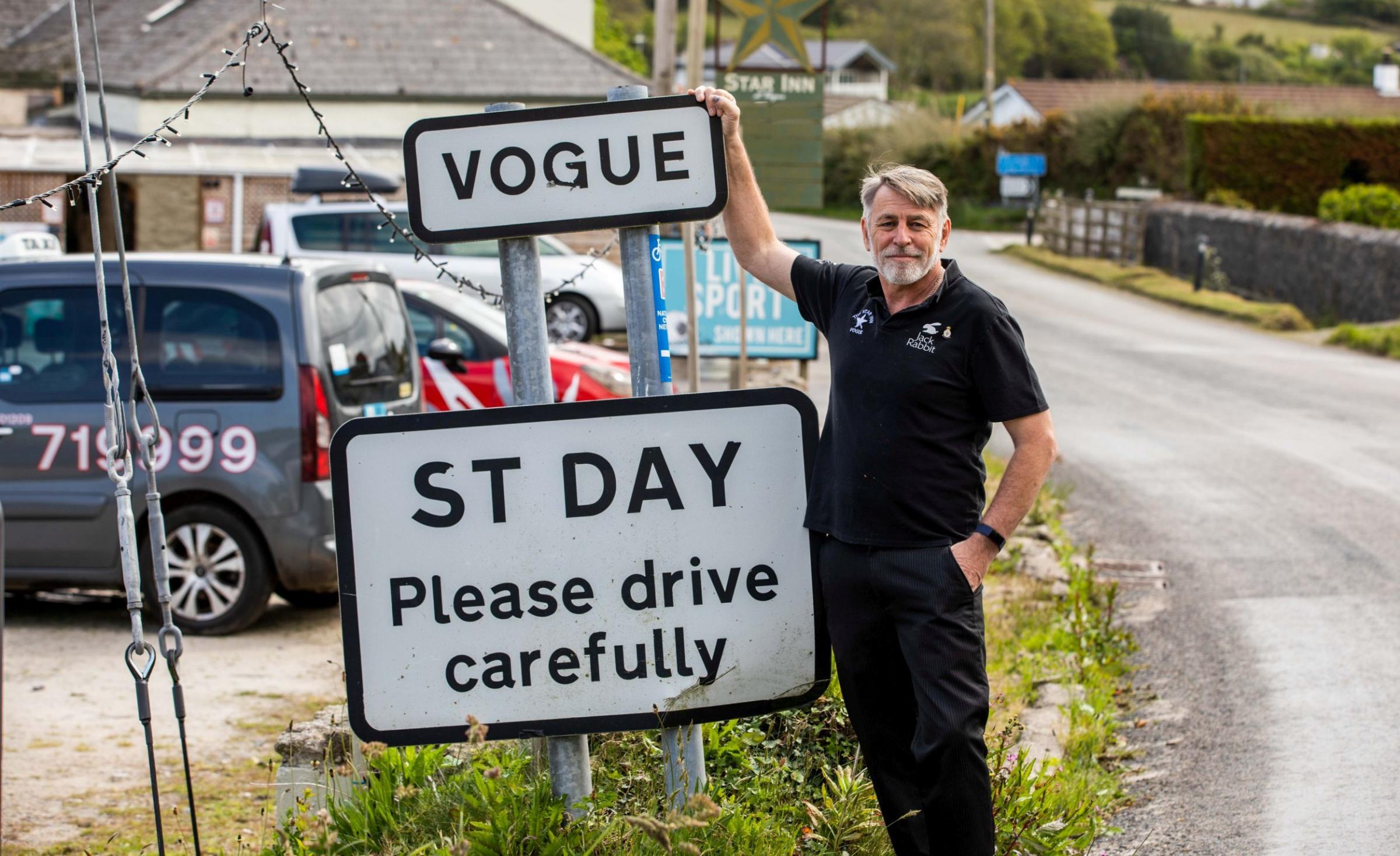 Mark shows the sign for the hamlet of Vogue, where there has been a pub for 200 years Picture: James Dadzitis / SWNS