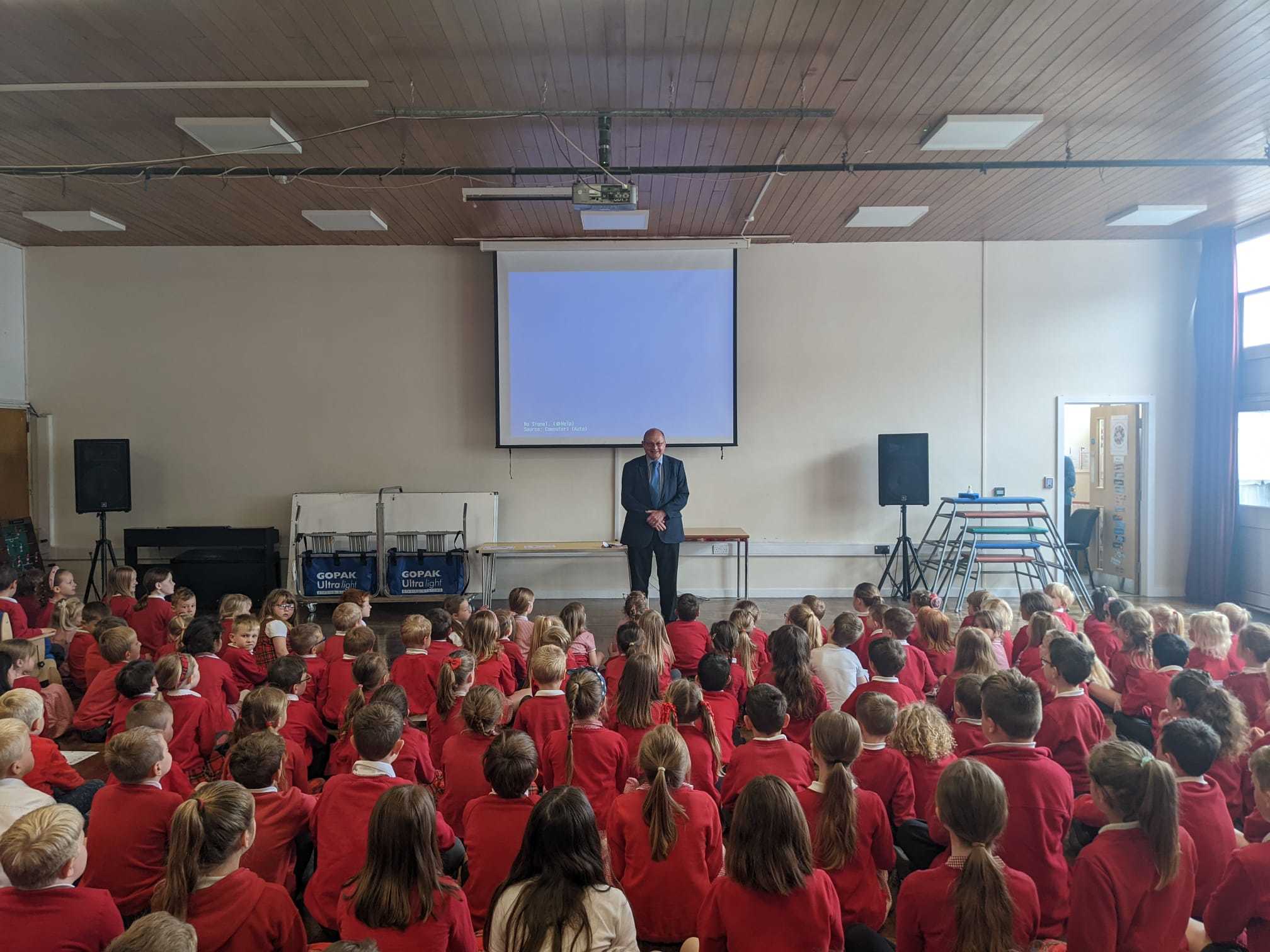 Brett taking an assembly with the pupils. 