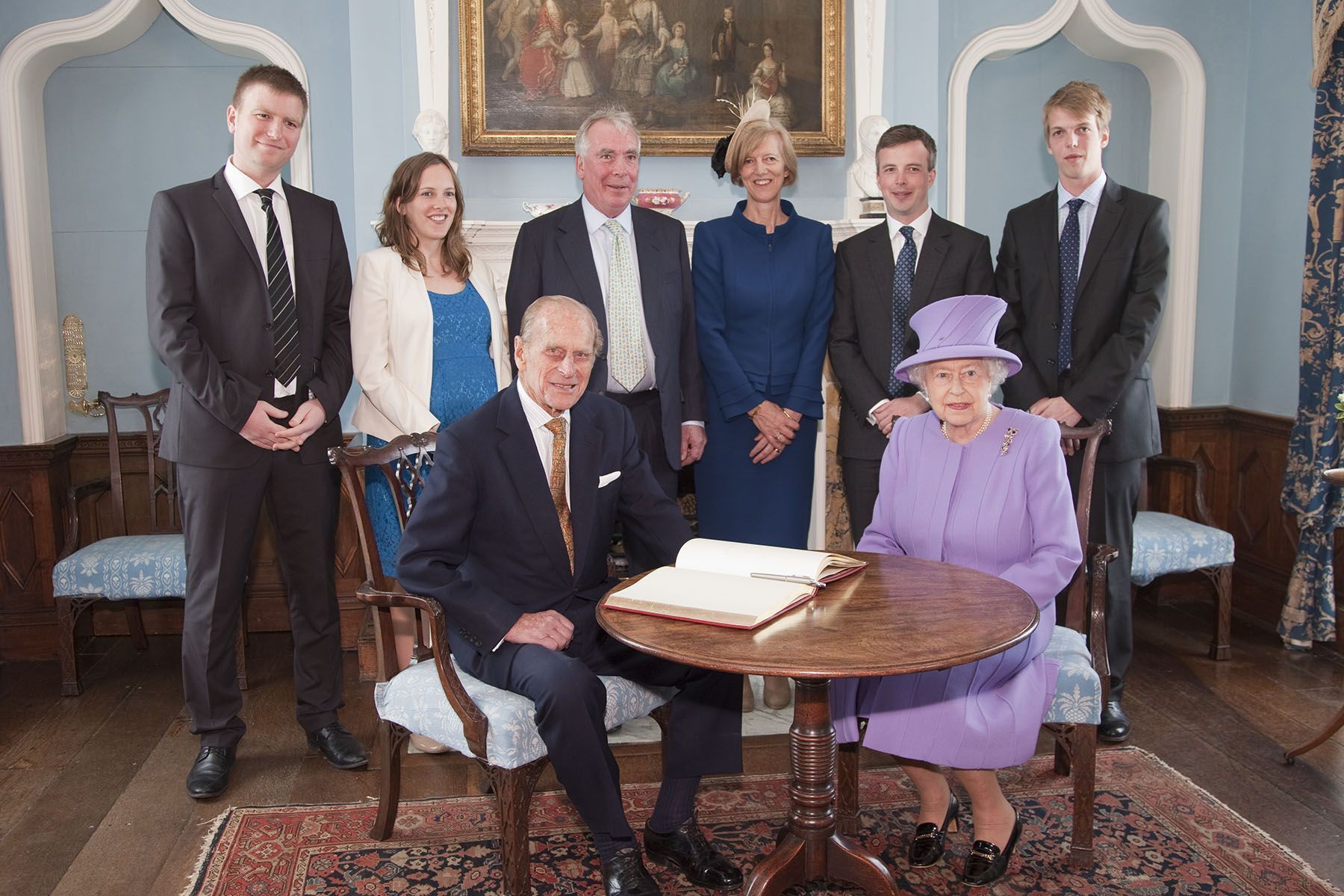 The Queen with the St Aubyn family having signed the vistors book.