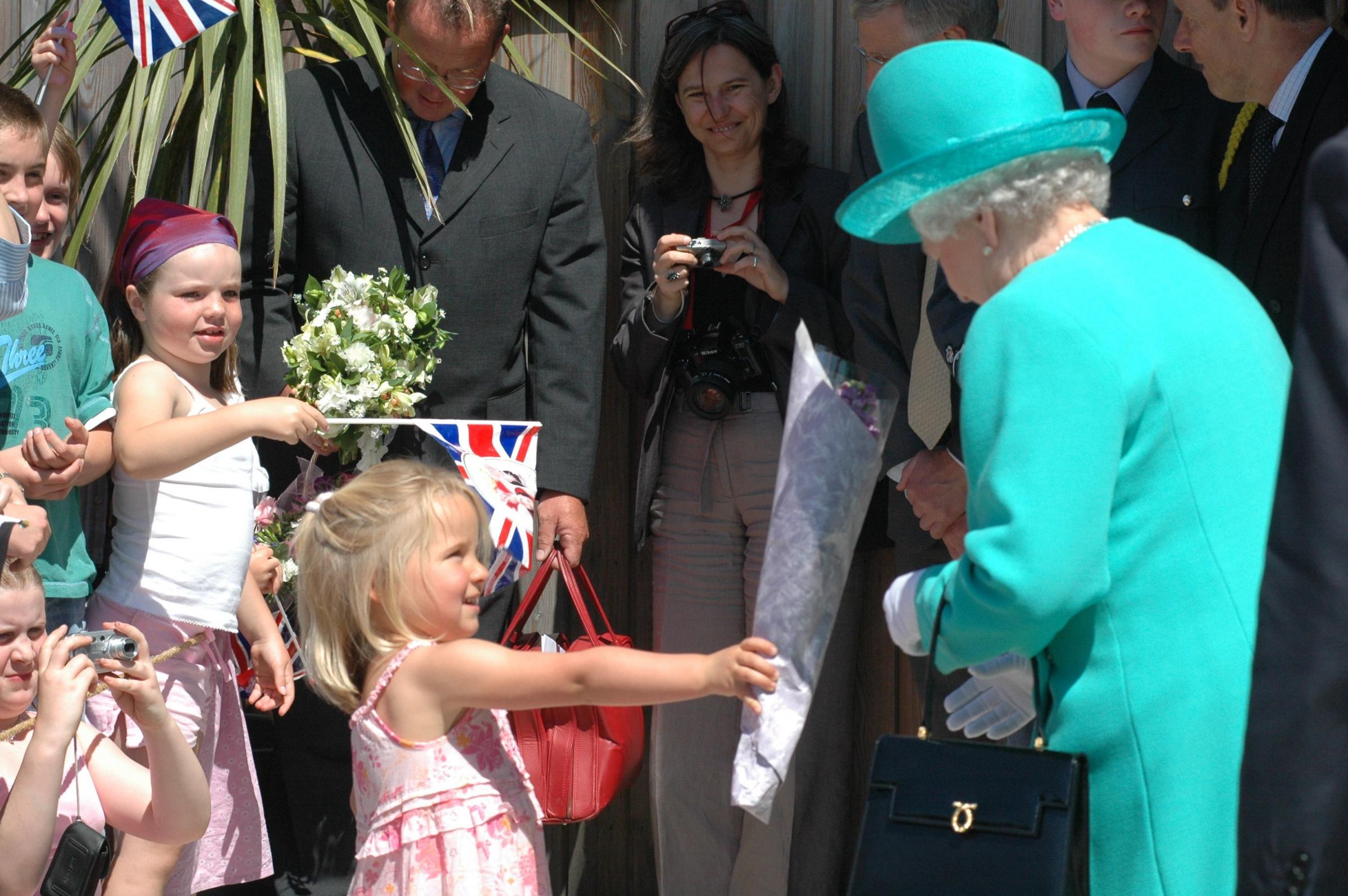 The Queen is presented with another bouquet at Tremough