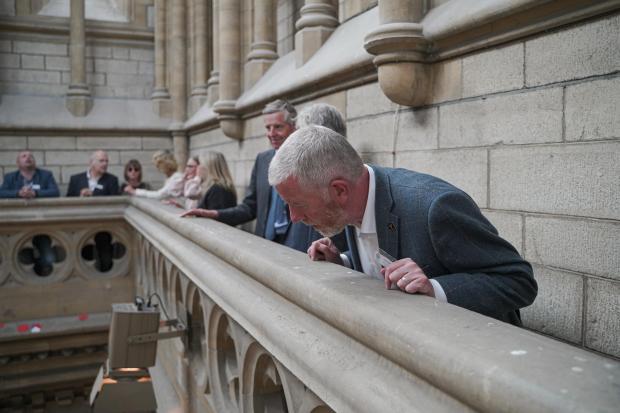 Falmouth Packet: Andy Snapes, Ward Williams Associates and other business leaders in Truro Cathedral's Victoria Tower watching choristers below. Picture: Hugh Hastings