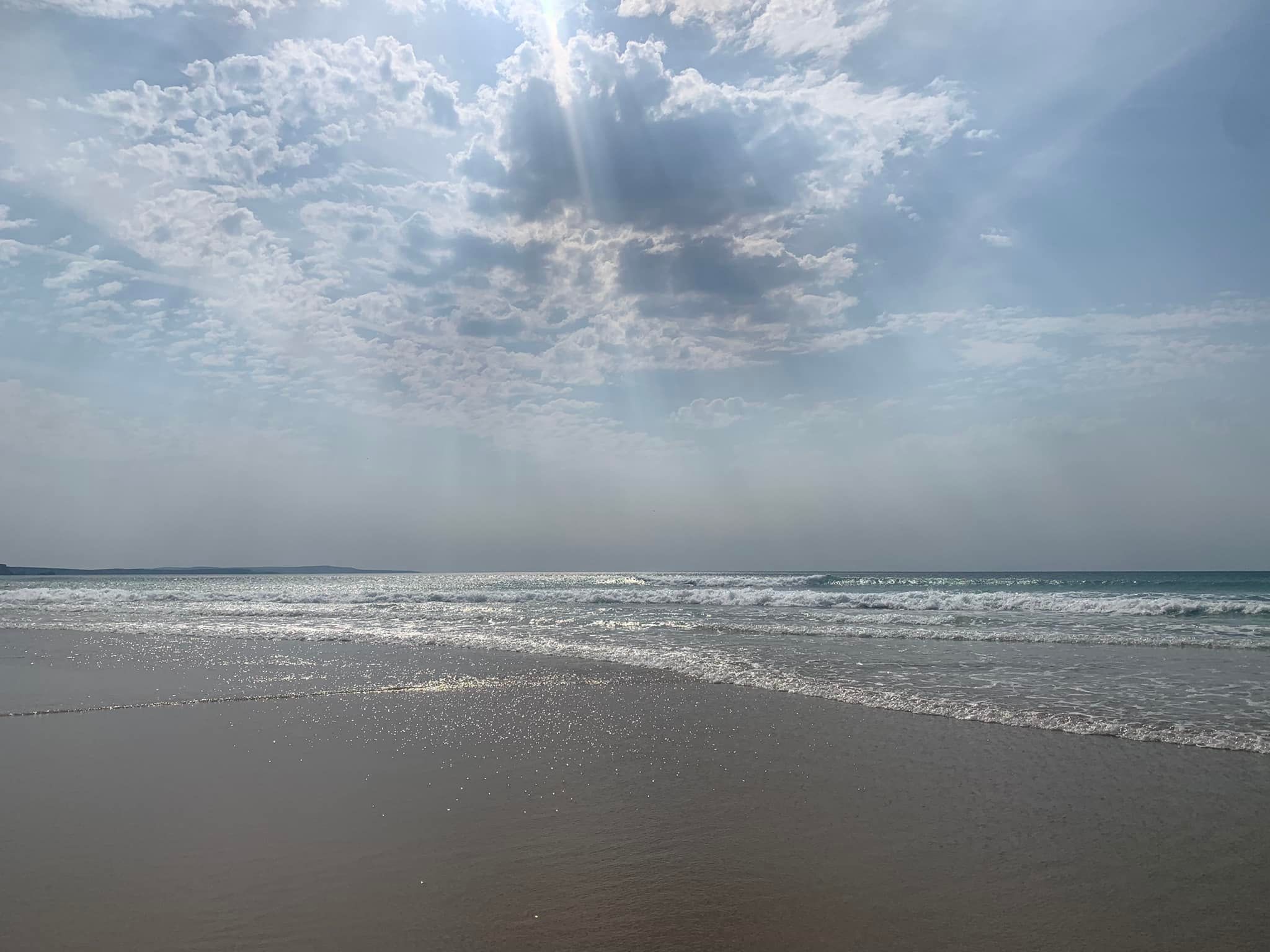 A ray of sunshine between the clouds and onto the beach. By Natalie Buswell