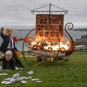 Environmental activists dressed as Boris Johnson and an oil tycoon set light to a Viking ship close to where G7 leaders are staying. Picture: Ocean Rebellion