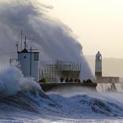 Waves crash against the sea wall and Porthcawl Lighthouse in Porthcawl, Bridgend, Wales, as Storm Eunice hits the south coast. Photo via PA.