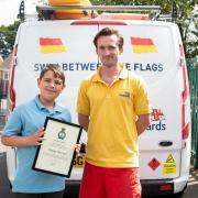 Finley Hassall, who used float to live advice to help another child who was struggling in the sea at Hayle, with lifeguard Guy Potter  Picture: RNLI/Nathan Williams