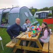 A family enjoy a meal at Wheal Vreagh Farm campsite