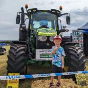 Four-year-old Reuben Mudge gives a thumbs up in front of Optimus Crime