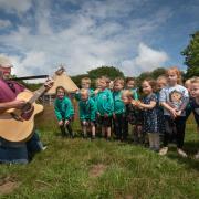 Will Keating performs school song with the children