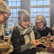 Jane Sutherland (centre) admires a gift from Creative Kernow colleagues and collaborators