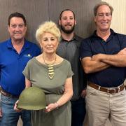Joan Doherty holds the returned helmet with her sons Frank and Darren and grandson Evan, centre.