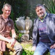 Trebah head gardener Darren Dickey and sculptor Reece Ingram sitting next to the Hibbert sculpture at Trebah Garden