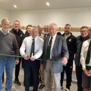 Chairman Gregg Renfree, flanked by club president David Rickard (right) and Carwinion Trust's Rex Sadler, MBE, cuts the ribbon at the opening ceremony (left)