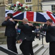 James' coffin is taken up the steps and into the cathedral