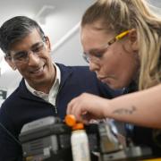 Prime Minister Rishi Sunak being shown how to splice a wire by field service engineer apprentice, Kiri James (right) during his visit to Wildanet Technical Training Academy in Liskeard, Cornwall, while on the General Election campaign trail.